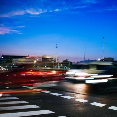 blurred cars speeding through intersection